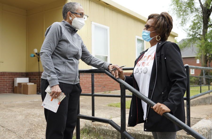 Laurna and masked woman speaking on steps