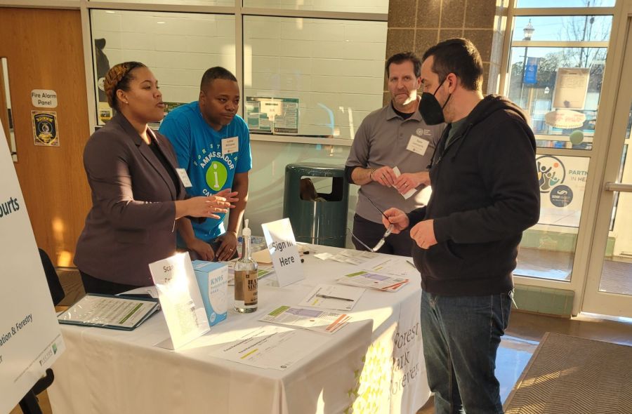 Darby at sign in table talking to attendee